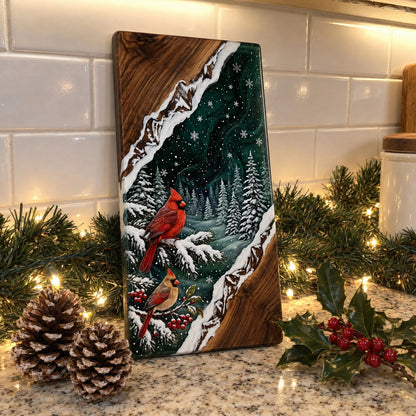 Cardinals Christmas board standing on a kitchen counter with a lit pine garland, pinecones and holly